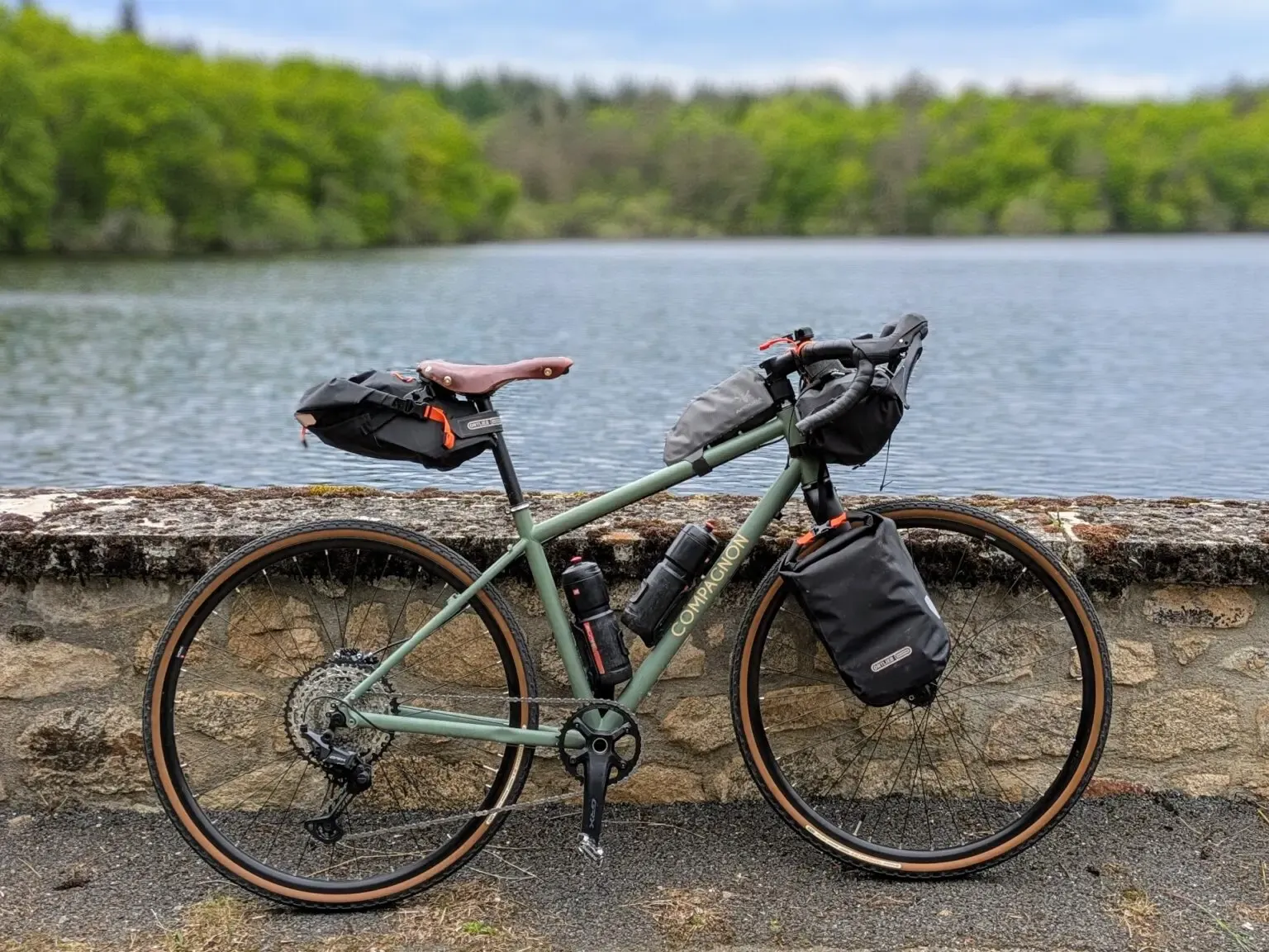 Vélo de voyage équipé de sacoches, à l'arrêt au bord d'un lac